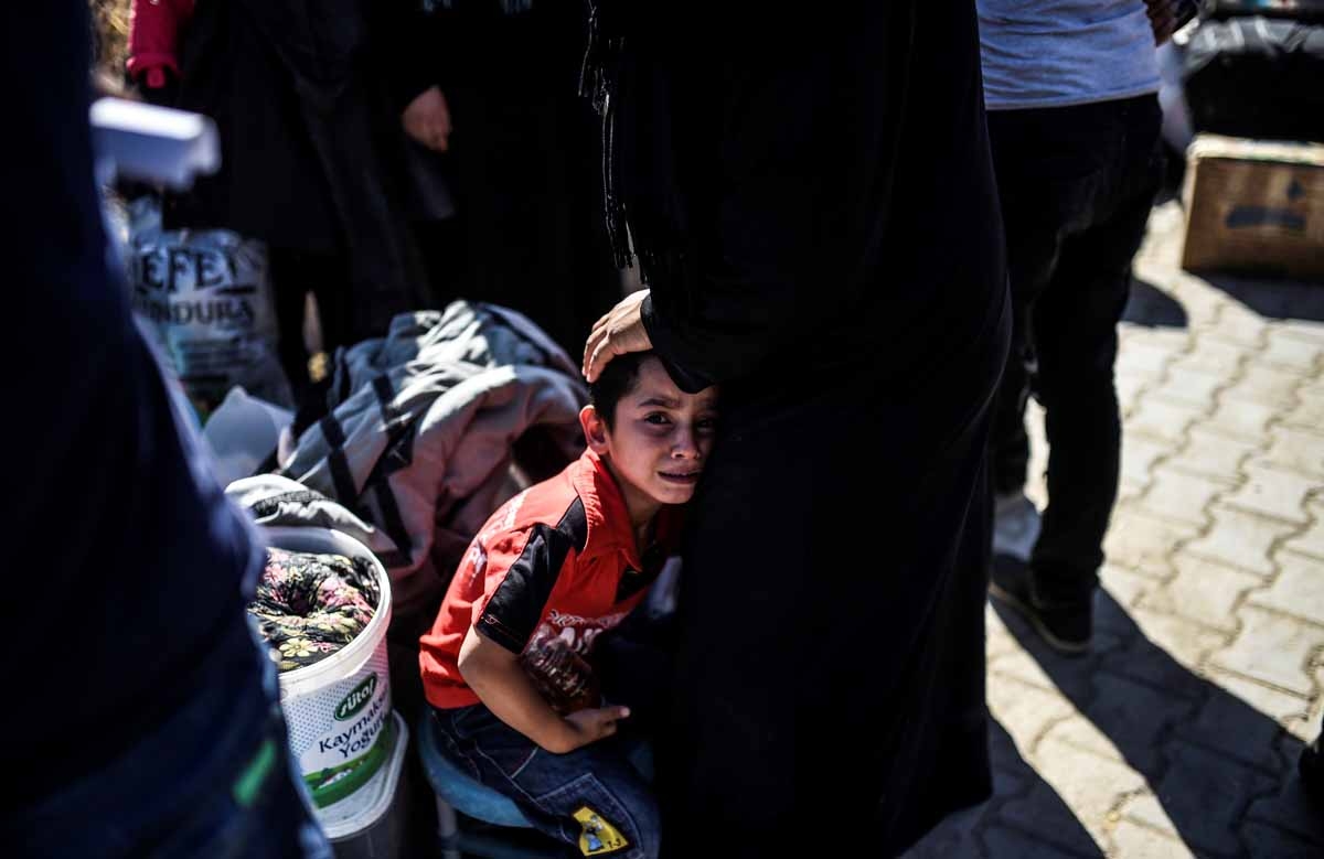 Syrian refugees walk on their way back to the Syrian city of Jarabulus on September 7, 2016 at Karkamis crossing gate, in the southern region of Kilis. Syrian refugees walk on their way back to the Syrian city of Jarabulus on September 7, 2016 at Karkamis crossing gate, in the southern region of Kilis.