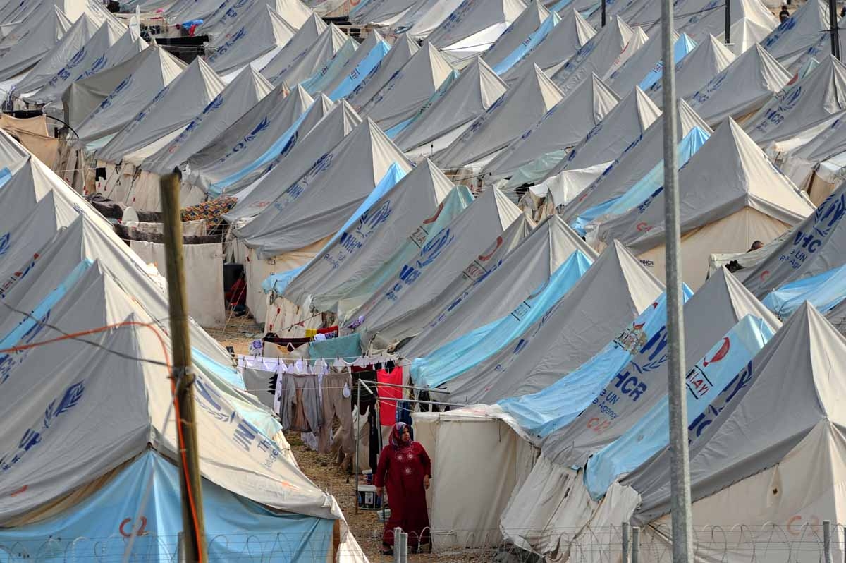 A Syrian refugee woman walks among tents at Karkamis' refugee camp on January 16, 2014 near the town of Gaziantep, south of Turkey. A Syrian refugee woman walks among tents at Karkamis' refugee camp on January 16, 2014 near the town of Gaziantep, south of Turkey.