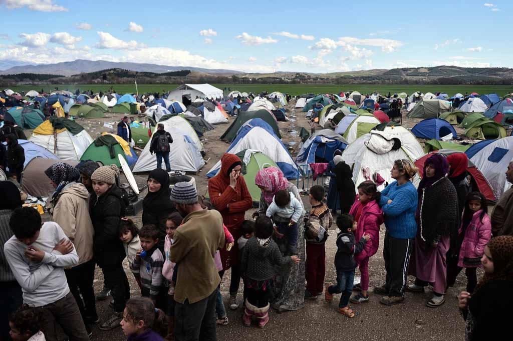 People queue for food at a makeshift camp near the Greek village of Idomeni at the Greek-Macedonian border, on March 4, 2016, where thousands of migrants and refugees are stranded.