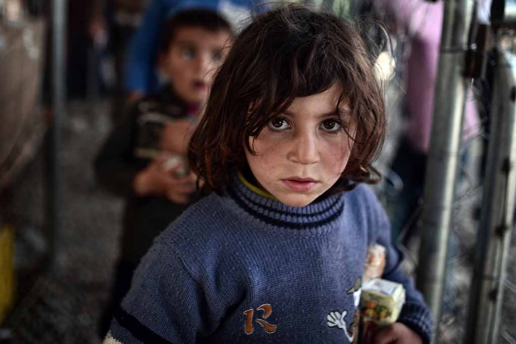 Children queue to receive food on March 6, 2016 in the makeshift camp at the Greek-Macedonian border near the village of Idomeni where thousands of refugees and migrants are stranded on March 6, 2016. 