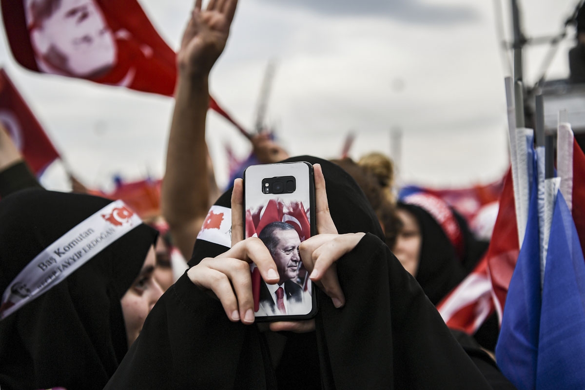 A supporter of the Turkish president and leader of the Justice and Development Party (AKP), takes a photograph on her mobile phone during his address at an AKP pre-election rally in Yenikapi Square in Istanbul on June 17, 2018.