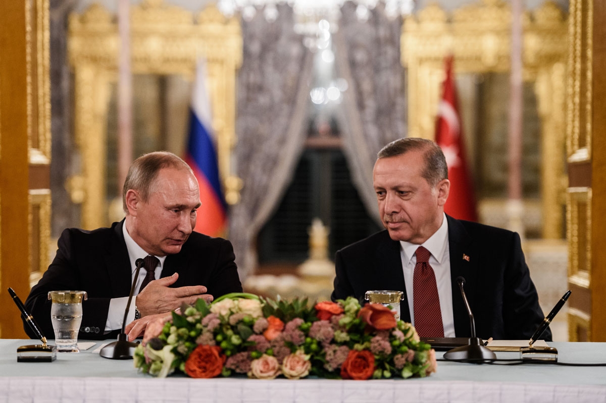 Russian President Vladimir Putin (L) speaks to Turkish President Recep Tayyip Erdogan (R) as they attend a press conference on October 10, 2016 in Istanbul.