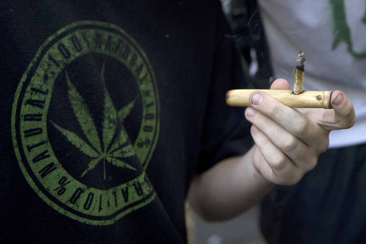 A man smokes a joint during a march for the legalization of marijuana towards the Legislative Palace in Montevideo, on December 10, 2013, as the Senate discuss a law on the legalization of marijuana's cultivation and consumption. Uruguays parliament is t