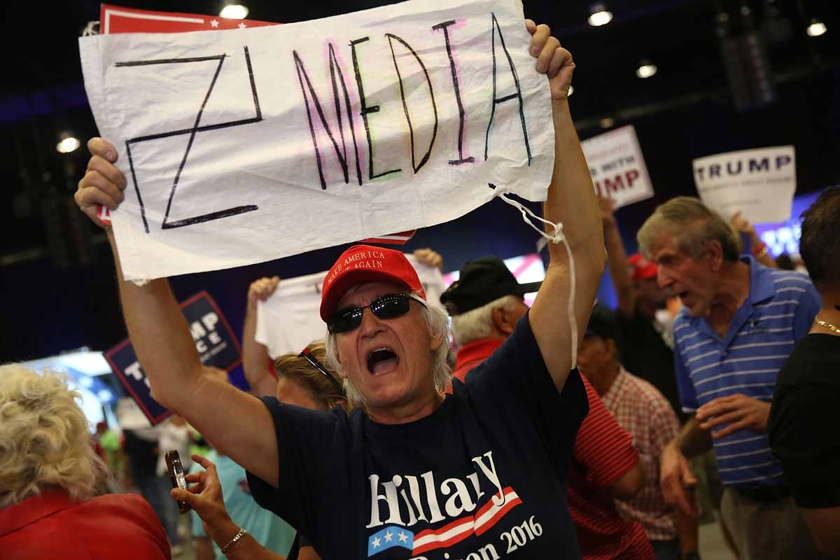 A man holds a sign towards the media as he attends a campaign rally for Republican presidential candidate Donald Trump at the South Florida Fair Expo Center on October 13, 2016 in West Palm Beach, Florida. A man holds a sign towards the media as he attends a campaign rally for Republican presidential candidate Donald Trump at the South Florida Fair Expo Center on October 13, 2016 in West Palm Beach, Florida.