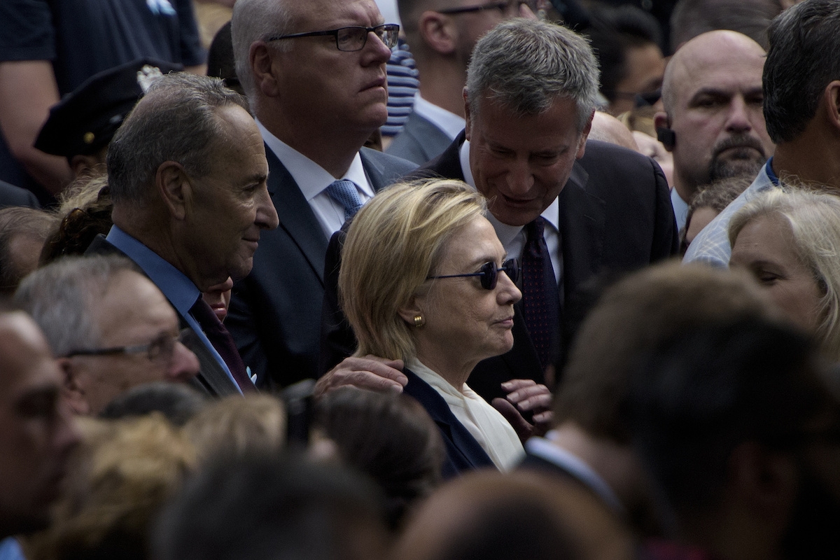 New York City Mayor Bill de Blasio speaks to US Democratic presidential nominee Hillary Clinton during a memorial service at the National 9/11 Memorial September 11, 2016 in New York.