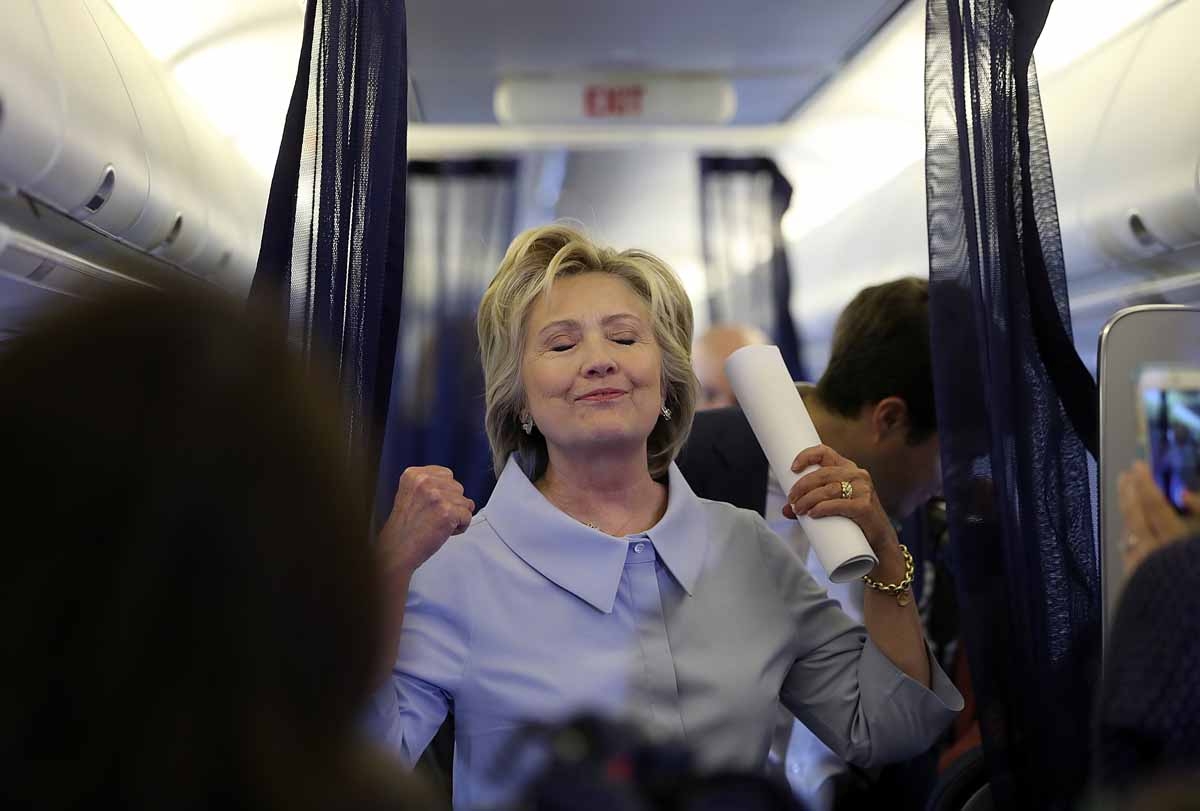WHITE PLAINS, NY - SEPTEMBER 05: Democratic presidential nominee former Secretary of State Hillary Clinton gestures as she chats with reporters aboard her new campaign plane at Westchester County Airport on September 5, 2016 in White Plains, New York.