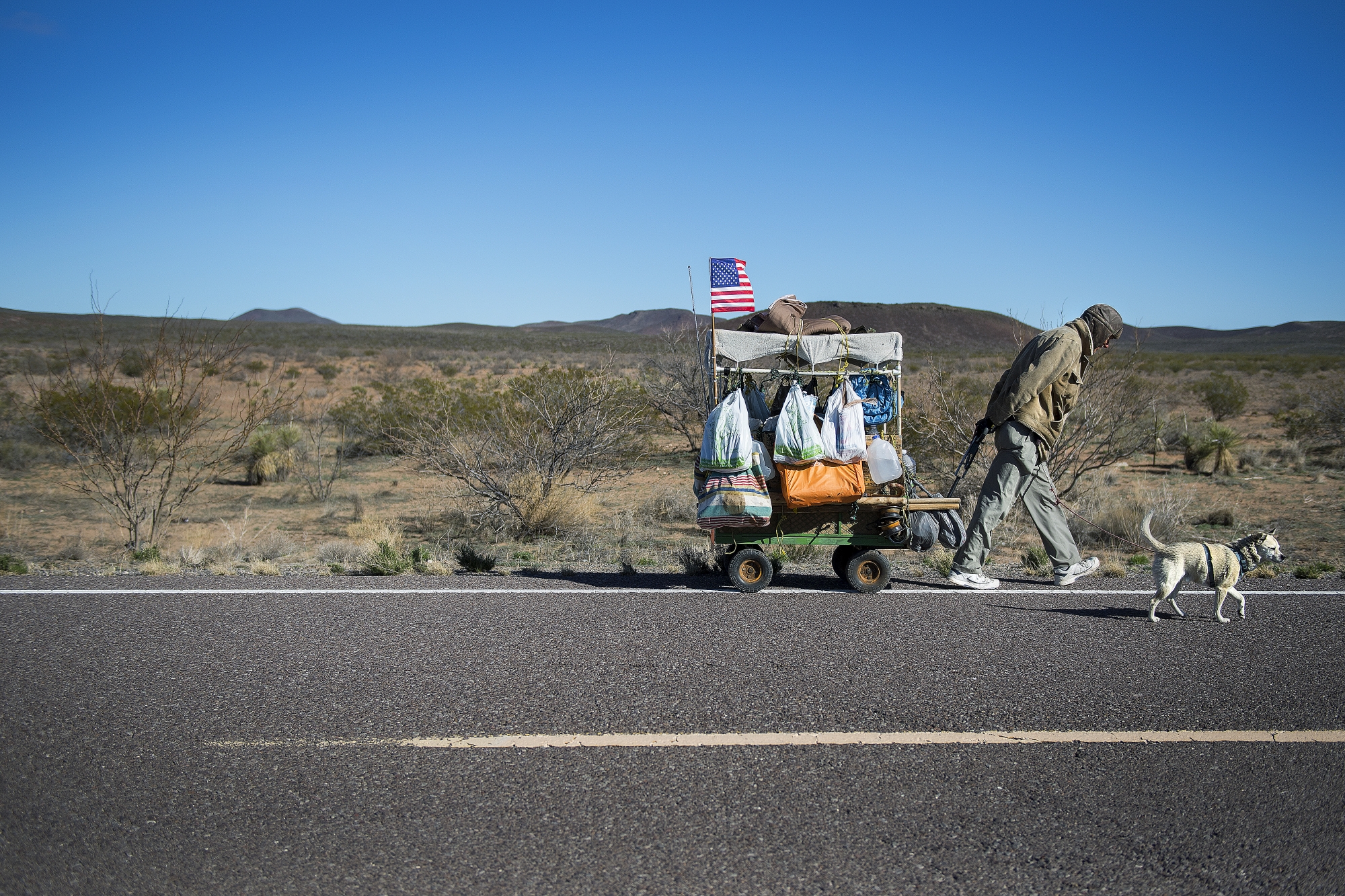 Self-proclaimed nomad Chris Kirkland walks along Country Road B002 while on a cross-country hike outside Columbus, New Mexico, on February 19, 2017, near the US/Mexico border.