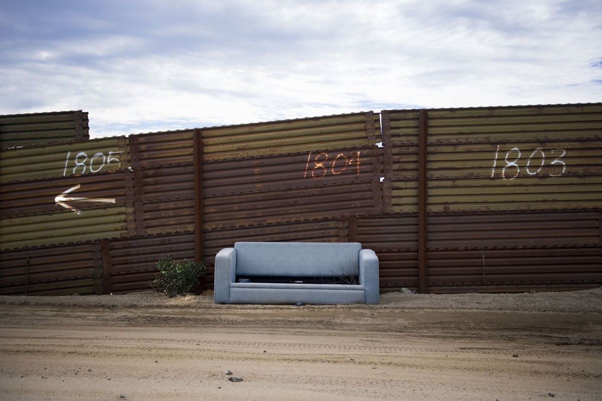 An abandoned sofa sits against the border fence on the US/Mexico border in Tecate, California on February 14, 2017.