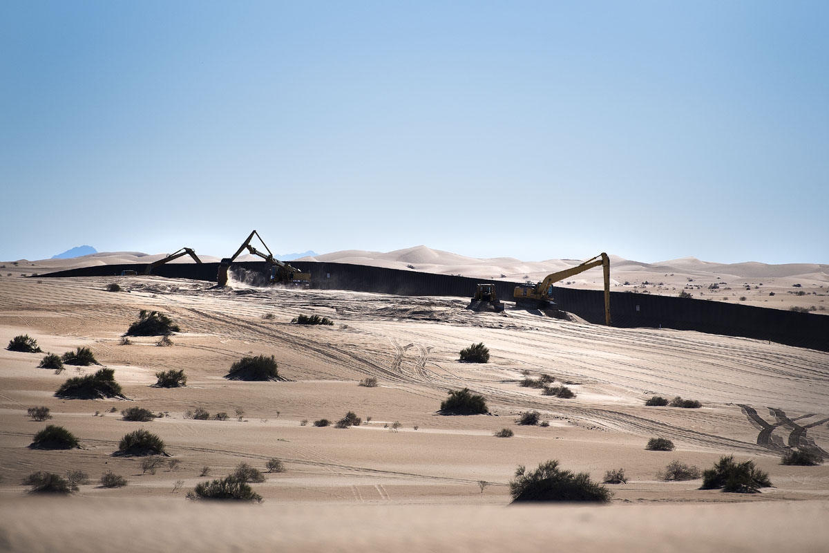 A construction crew works near the border fence on the US/Mexico border at the Imperial Sand Dunes in Dunes, CA, on February 15, 2017.