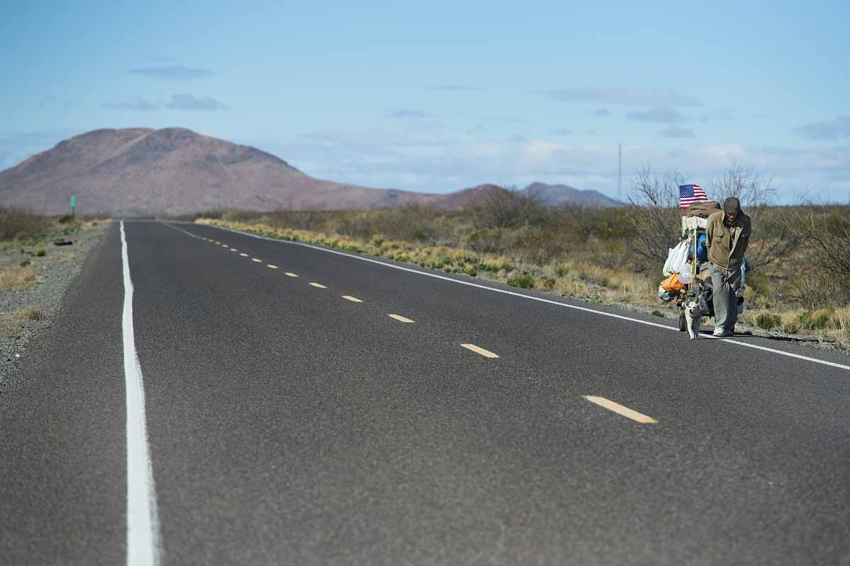 Self-proclaimed nomad Chris Kirkland walks along Country Road B002 while on a cross-country hike outside Columbus, New Mexico, on February 19, 2017, near the US/Mexico border.