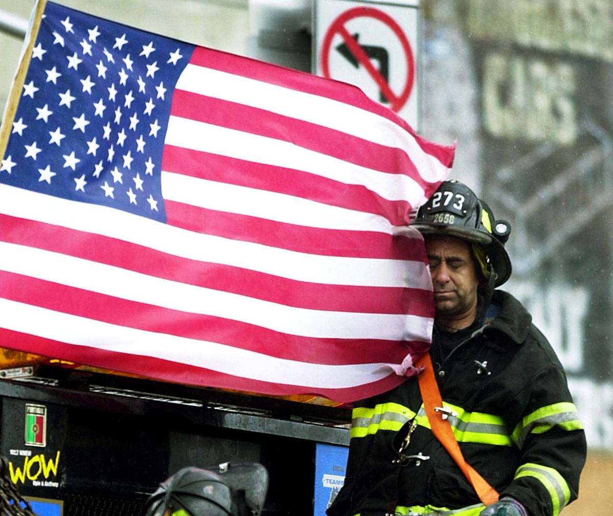 A tired fireman rests as he rides on the back of a flatbed truck 14 September 2001 in New York.