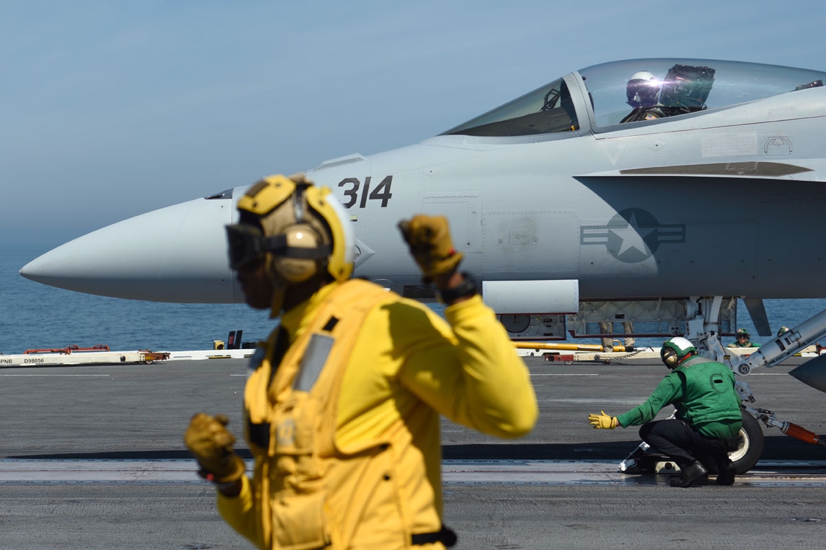 Le Catapult officer Nigel (L) gestures as a US Navy F/18 Hornet jet is catapulted off the USS George H.W. Bush aircraft carrier on May 11, 2018 in the Atlantic Ocean.