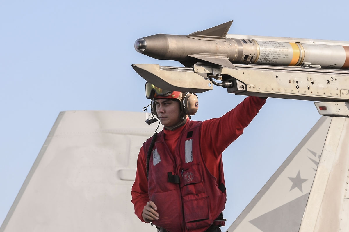 A crew member touches a missile on an F18 Hornet fighter jet stationed on the deck of the US navy aircraft carrier USS Harry S. Truman in the eastern Mediterranean Sea on May 8, 2018.