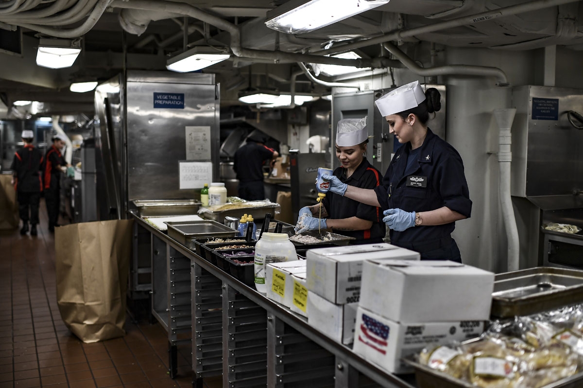 Crew members of the 330 meters aircraft US carrier Harry S Truman prepare meals in the kitchen of the warship on eastern Mediterranean Sea on May 8, 2018.