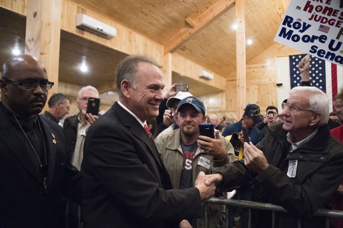 Republican Senatorial candidate Roy Moore shakes hands as he arrives to speak at a rally in Midland, Alabama, on December 11, 2017