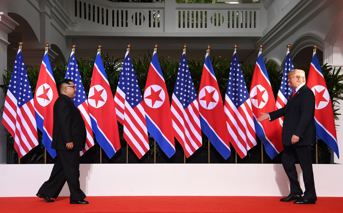US President Donald Trump (R) and North Korea's leader Kim Jong Un (L) walk toward one another at the start of their historic US-North Korea summit, at the Capella Hotel on Sentosa island in Singapore on June 12, 2018.