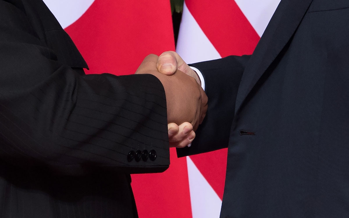 US President Donald Trump (R) shakes hands with North Korea's leader Kim Jong Un (L) at the start of their historic US-North Korea summit, at the Capella Hotel on Sentosa island in Singapore on June 12, 2018.