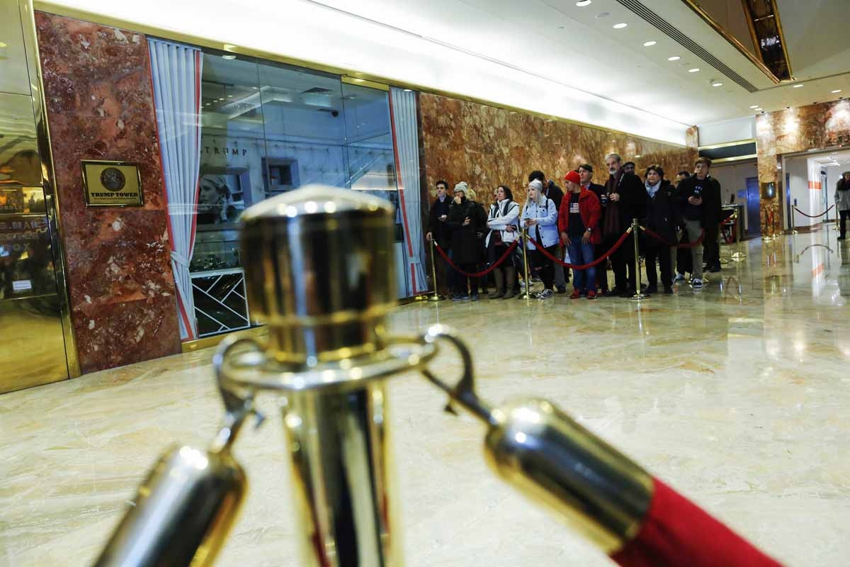 People wait to have a look at politicians going in and out of elevators at Trump Tower on another day of meetings scheduled for US President-elect Donald Trump on November 21, 2016 in New York. People wait to have a look at politicians going in and out of elevators at Trump Tower on another day of meetings scheduled for US President-elect Donald Trump on November 21, 2016 in New York.