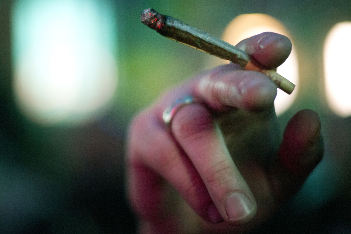 A member of the International Church of Cannabis holds a joint while participating in a 4/20 celebration on April 20, 2018 in Denver, Colorado.