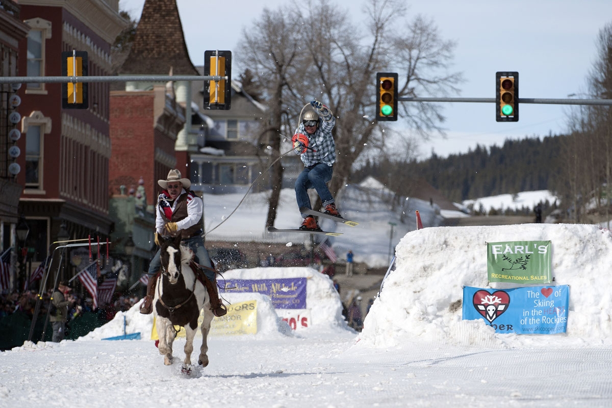 Rider Jeff Dahl races down Harrison Avenue while skier and son Greg Dahl airs out off the final jump of the Leadville skijoring course during the 68th annual Leadville Ski Joring weekend competition on Saturday, March 4, 2017 in Leadville, Colorado.