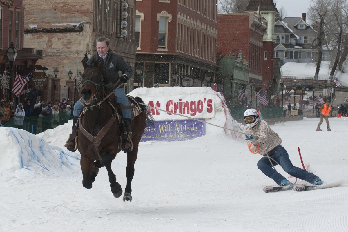Rider Dana Stiles races down Harrison Avenue towing skier Mike Fries during the 68th annual Leadville Ski Joring weekend competition on March 5, 2017 in Leadville, Colorado.