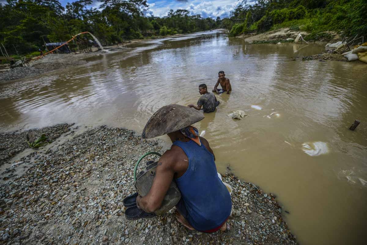 Men work at Nacupay gold mine on the bank of a river in El Callao, Bolivar state, southeastern Venezuela on February 24, 2017.