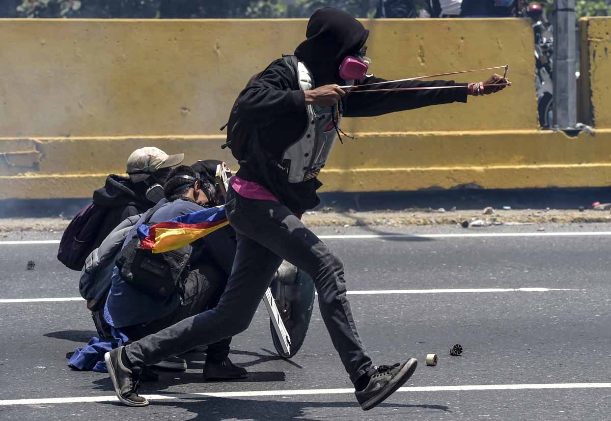 Opposition activists clash with riot police during a protest in Caracas on April 26, 2017.