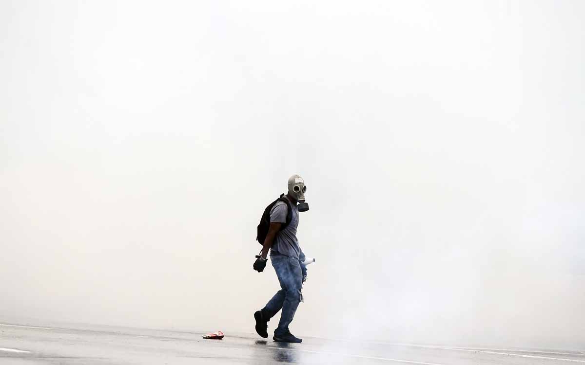 Opposition activists protesting against the government of Nicolas Maduro clash with riot police in Caracas on April 13, 2017. A 32-year-old man died late Thursday after being shot and wounded in a demonstration against President Nicolas Maduro last Tuesda