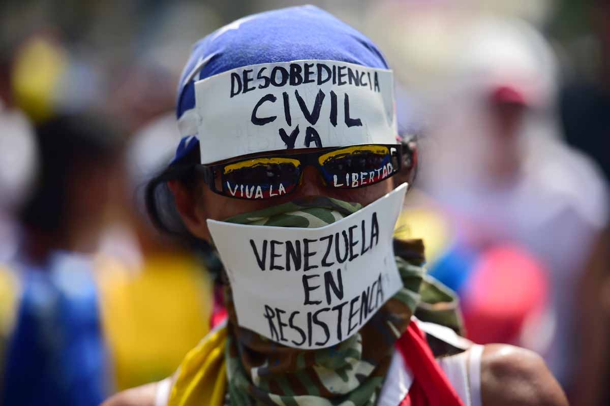 A demonstrator against President Nicolas Maduro's government calls to Civil Disobedience during a protest at the east side of Caracas on April 19, 2017.