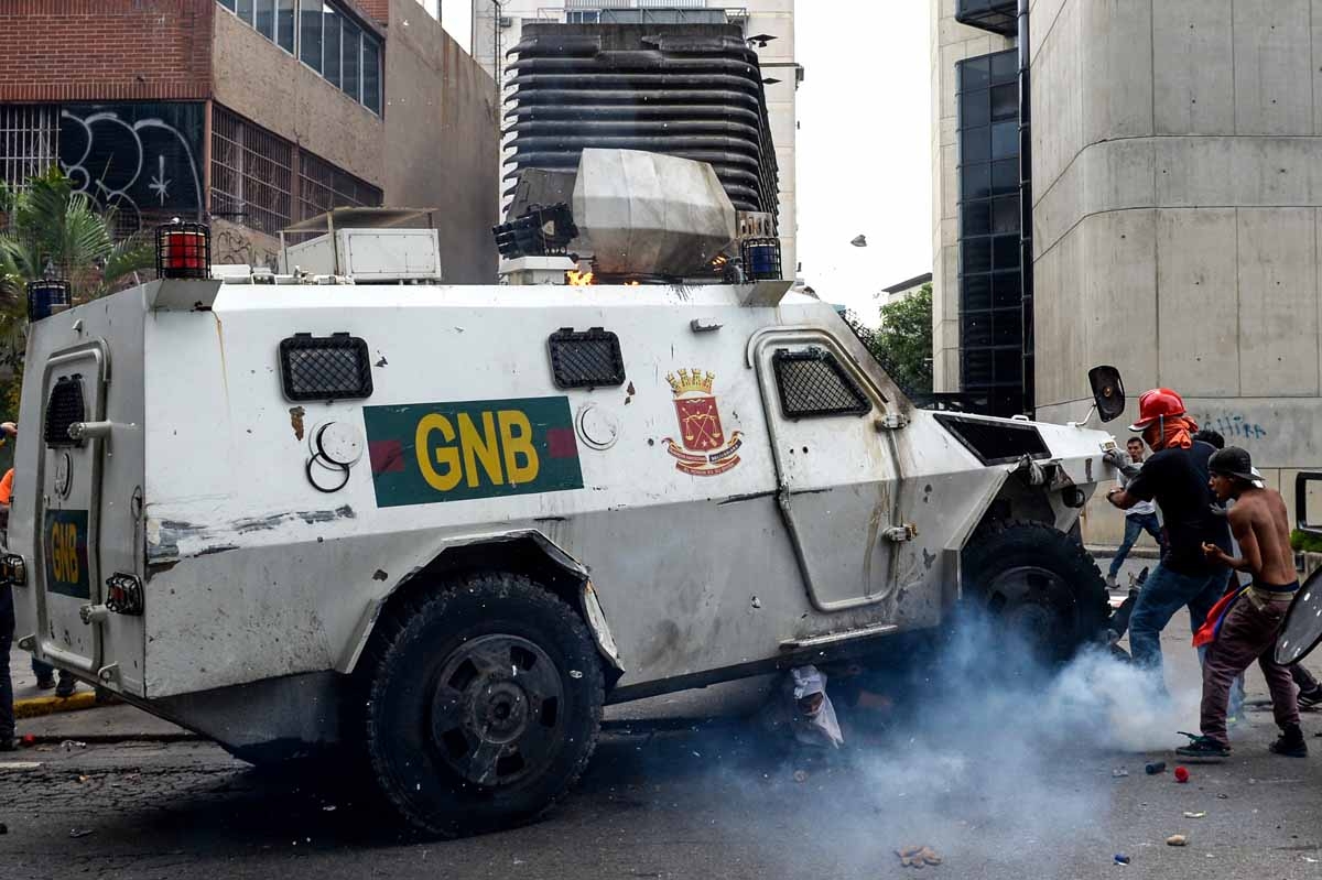 A Venezuelan National Guard riot control vehicle runs over an opposition demonstrator during a protest against Venezuelan President Nicolas Maduro, in Caracas on May 3, 2017.