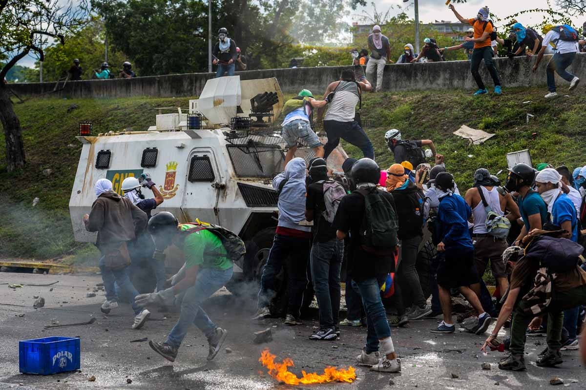 Manifestantes se apoderan de un vehículo antimotines de la policía durante protestas contra el presidente Nicolás Maduro, en Caracas, el 1 de mayo de 2017.