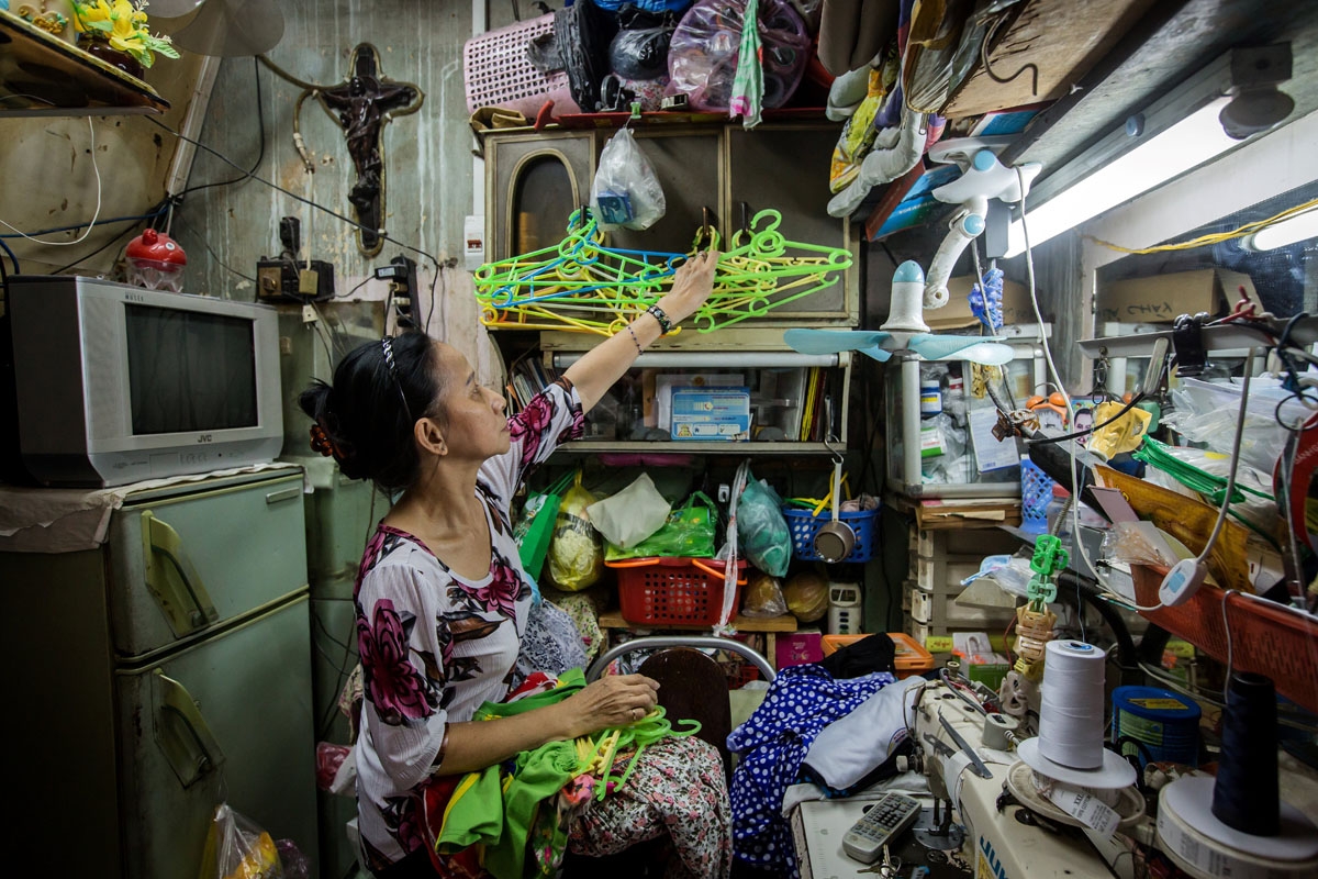 Nguyen Thi Kim Ngoc arranges cloth-hangers in her 6.7-square-metre home in Ho Chi Minh City on May 3, 2018.