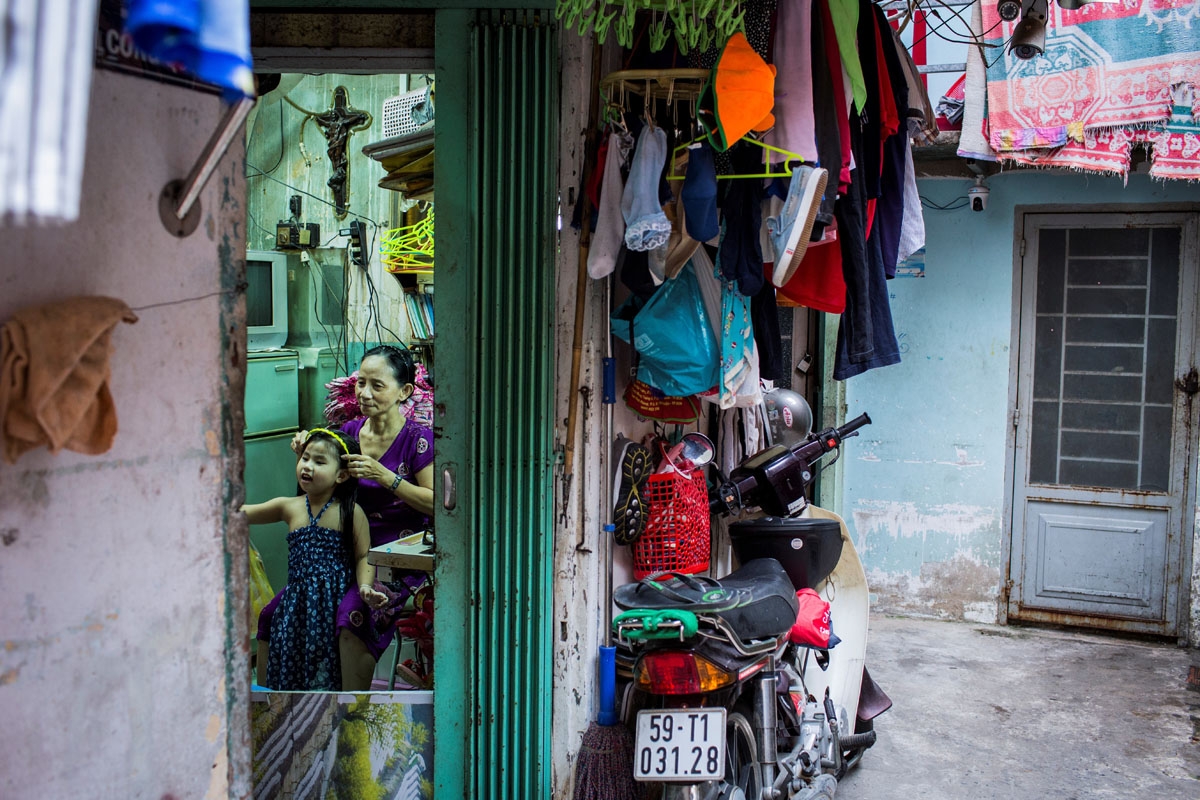 Nguyen Thi Kim Ngoc fixes her granddaughter's hair in her 6.7-square-metre home in Ho Chi Minh City on May 15, 2018.
