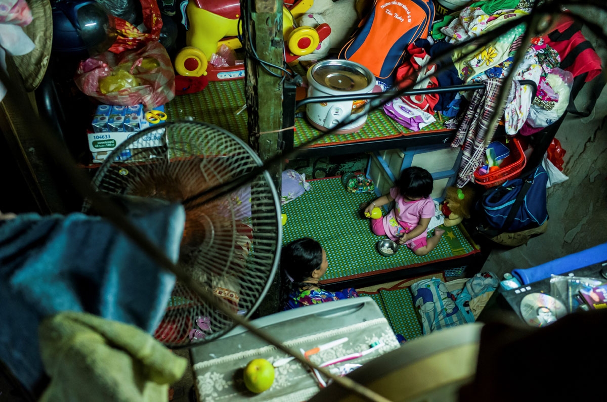 A woman and a child are seen inside one of their relative's two-square-metre home in Ho Chi Minh City on May 2, 2018.