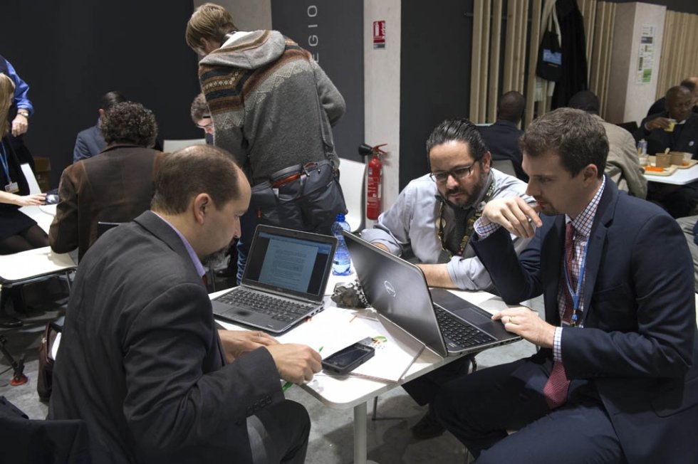 Delegates read copies of the COP21 agreement. December 12, 2015. Delegates read copies of the COP21 agreement. December 12, 2015.