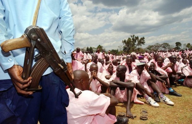 Pink flamingos: A guard stands in front of some of more than 2,000 prisoners suspected of taking part in the 1994 Rwandan genocide. They were gathered in Butare's stadium, and were made to face victims of the massacre. September 29, 2002. Pink flamingos: A guard stands in front of some of more than 2,000 prisoners suspected of taking part in the 1994 Rwandan genocide. They were gathered in Butare's stadium, and were made to face victims of the massacre. September 29, 2002.
