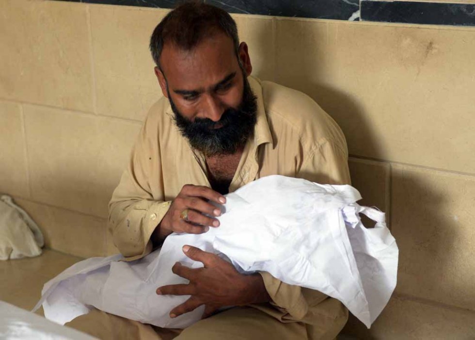 A Pakistani man carries the body of his three-year-old son, killed in the heatwave, at the Edhi morgue in Karachi on June 22, 2015 A Pakistani man carries the body of his three-year-old son, killed in the heatwave, at the Edhi morgue in Karachi on June 22, 2015