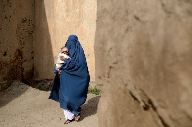 A burqa-clad Afghan villager carries a small child as she walks among a collection of destroyed buildings in the village of Deh Saqi on The Shomali Plains some 20 kms north of Kabul. A burqa-clad Afghan villager carries a small child as she walks among a collection of destroyed buildings in the village of Deh Saqi on The Shomali Plains some 20 kms north of Kabul.
