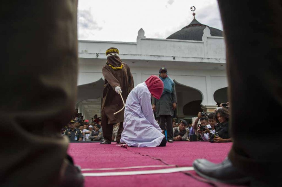 An Acehnese woman convicted for 'immoral acts' is lashed by a hooded local government officer during a public caning at a square in Banda Aceh, Aceh province, on June 12, 2015. (AFP PHOTO / Chaideer MAHYUDDIN) An Acehnese woman convicted for 'immoral acts' is lashed by a hooded local government officer during a public caning at a square in Banda Aceh, Aceh province, on June 12, 2015. (AFP PHOTO / Chaideer MAHYUDDIN)