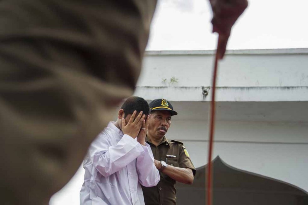 An Acehnese man convicted for 'immoral acts' prepares for punishment to be administered by a hooded local government officer during a public caning at a square in Banda Aceh, Aceh province, on June 12, 2015. (AFP PHOTO / Chaideer MAHYUDDIN) An Acehnese man convicted for 'immoral acts' prepares for punishment to be administered by a hooded local government officer during a public caning at a square in Banda Aceh, Aceh province, on June 12, 2015. (AFP PHOTO / Chaideer MAHYUDDIN)