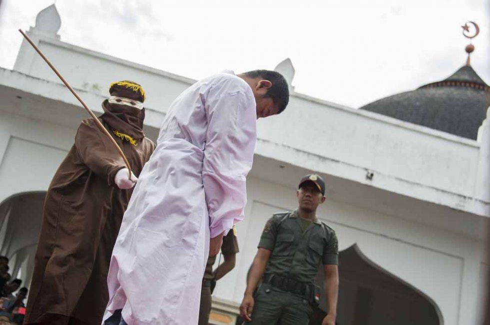 An Acehnese man convicted for 'immoral acts' is lashed by a hooded local government officer during a public caning at a square in Banda Aceh, Aceh province, on June 12, 2015. (AFP PHOTO / Chaideer MAHYUDDIN) An Acehnese man convicted for 'immoral acts' is lashed by a hooded local government officer during a public caning at a square in Banda Aceh, Aceh province, on June 12, 2015. (AFP PHOTO / Chaideer MAHYUDDIN)