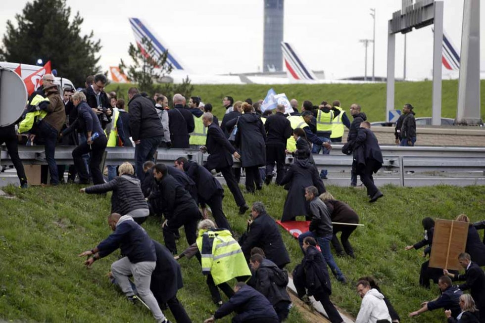 A crowd of Air France employees charges up a hill. A crowd of Air France employees charges up a hill.