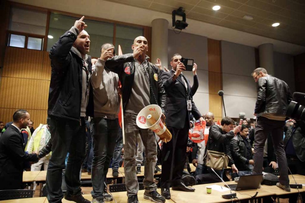 Protesters shout slogans on top of tables after bursting into a conference room during a management meeting. Protesters shout slogans on top of tables after bursting into a conference room during a management meeting.