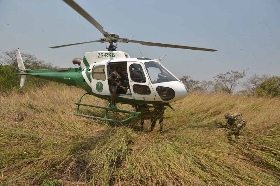 Rangers run toward a helicopter to be transported to a new spot within the park. Rangers run toward a helicopter to be transported to a new spot within the park.