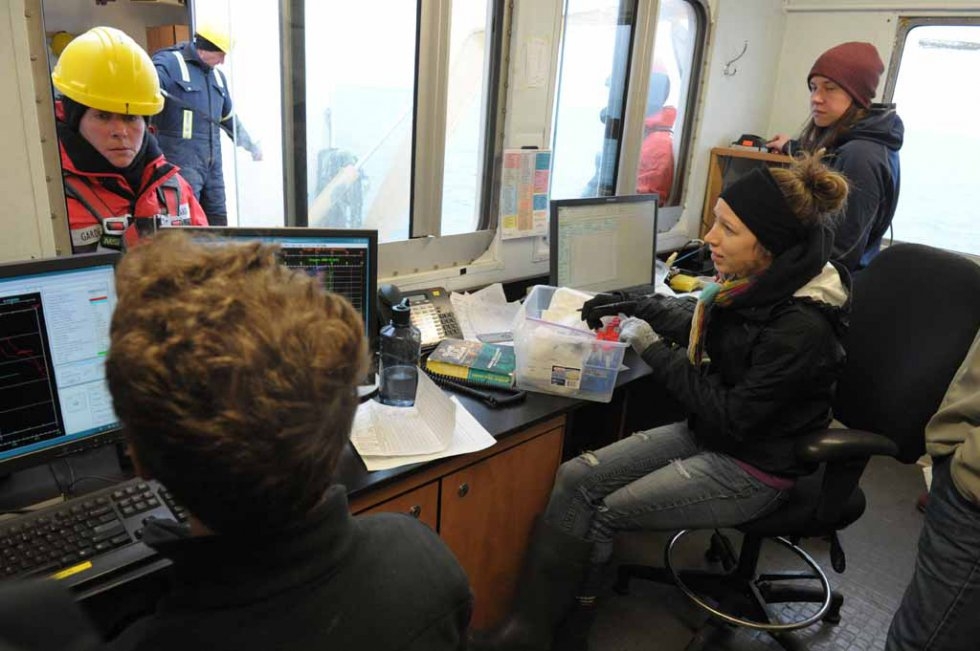 Scientists aboard monitor devices deployed in the water Scientists aboard monitor devices deployed in the water