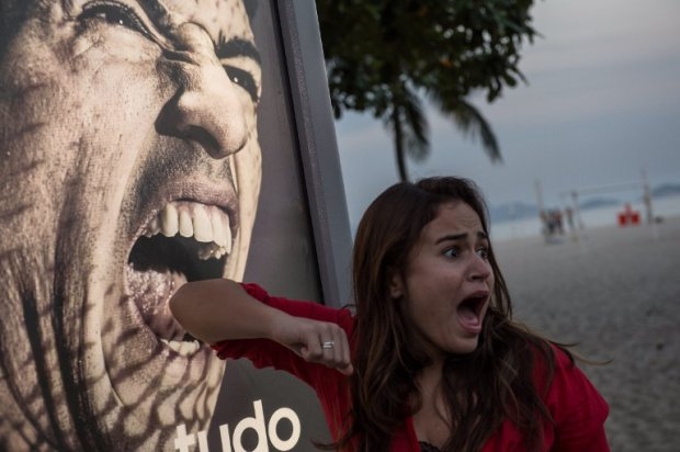 A tourist jokes in front of an advertisement showing Luis Suarez, in Rio de Janeiro, June 26, 2014. A tourist jokes in front of an advertisement showing Luis Suarez, in Rio de Janeiro, June 26, 2014.