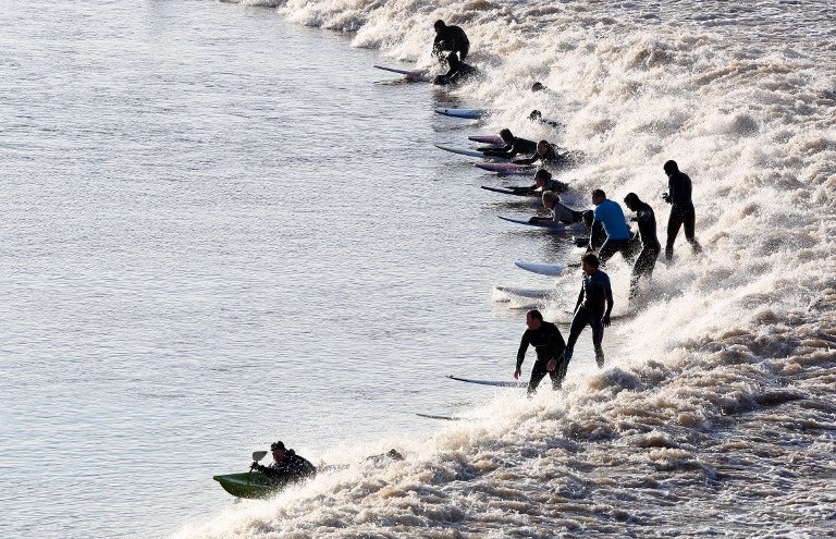 Surfers ride the Severn bore at Newnham, southwest England on March 21, 2015 Surfers ride the Severn bore at Newnham, southwest England on March 21, 2015