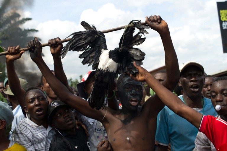 Protesters hold a dead bird in the Musaga neighbourhood of Bujumbura, on May 4, 2015 Protesters hold a dead bird in the Musaga neighbourhood of Bujumbura, on May 4, 2015