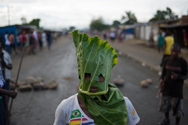 A Burundian protester wearing a gas mask chants near a burning barricade in the Mugasa neighbourhood of Bujumbura on May 6, 2015 A Burundian protester wearing a gas mask chants near a burning barricade in the Mugasa neighbourhood of Bujumbura on May 6, 2015