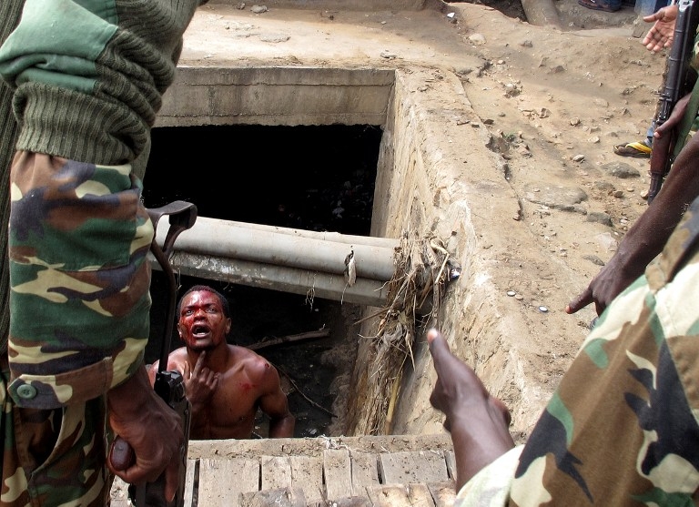 A man suspected of being an 'Imbonerakure' begs military officers for help, from a gutter where he hid on May 7, 2015 to escape a mob lynching in the Cibitoke district of Bujumbura. A man suspected of being an 'Imbonerakure' begs military officers for help, from a gutter where he hid on May 7, 2015 to escape a mob lynching in the Cibitoke district of Bujumbura.